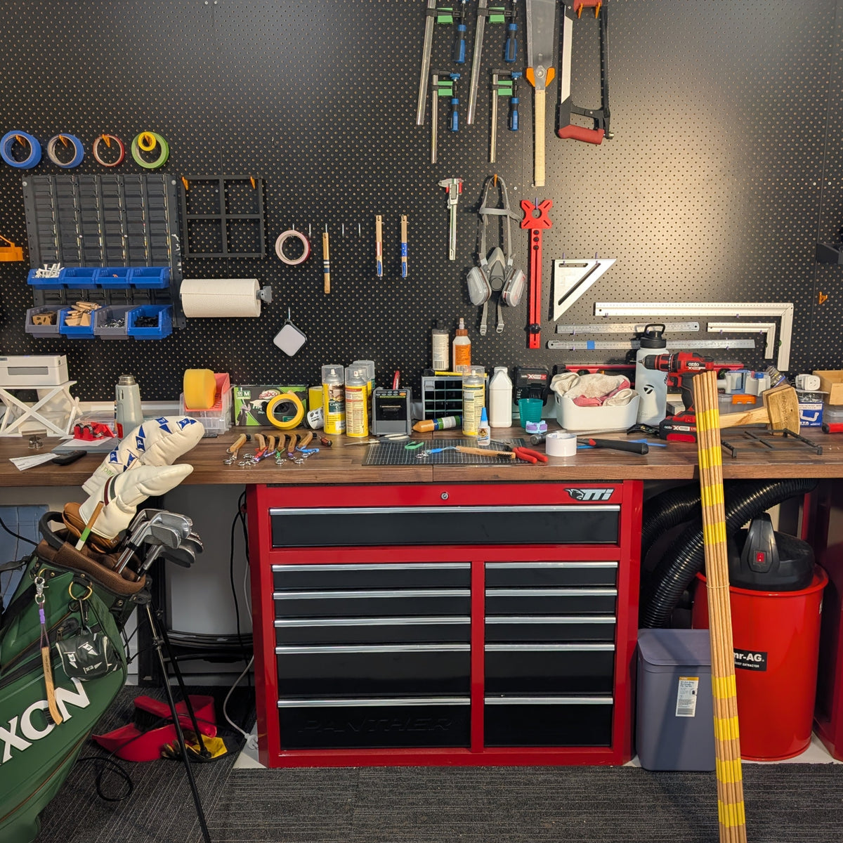 Organized workshop with tools and equipment on a pegboard and workbench.