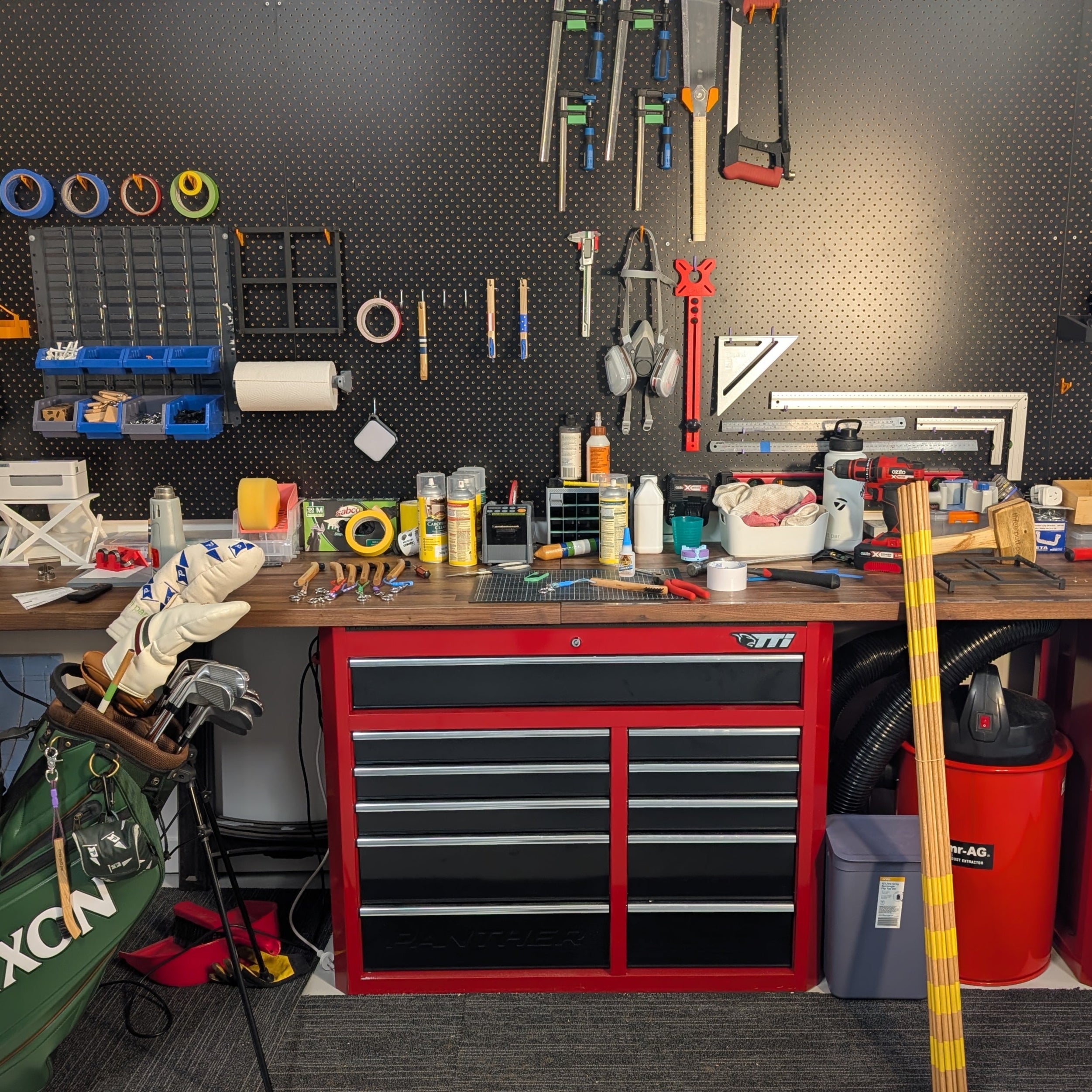 Organized workshop with tools and equipment on a pegboard and workbench.